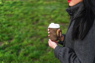 Kız sıcak kahve içiyor. 