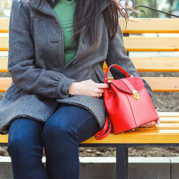 Женщина сидит с красной сумкой — стоковое фото