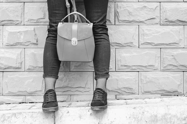 Women's feet near brick wall with backpack — Stock Photo, Image