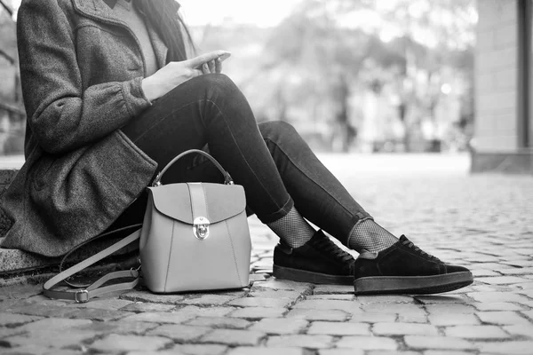 Brunette girl sitting on street — Stock Photo, Image