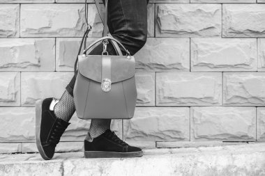 Kadın ayakları yakınındaki duvara sırt çantası ile