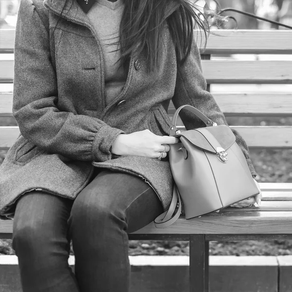 Mulher sentada no banco com saco nas mãos — Fotografia de Stock