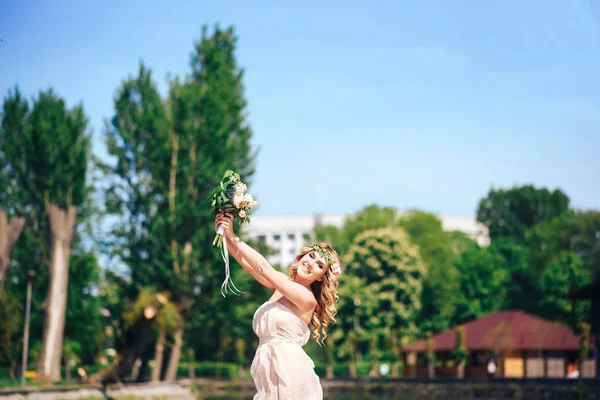 Jonge bruid met bruiloft boeket — Stockfoto