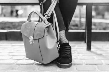 Çanta ile bankta oturan kadın