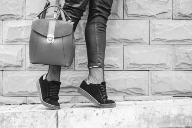 ayakları ile sırt çantası elinde duvarının yakınında