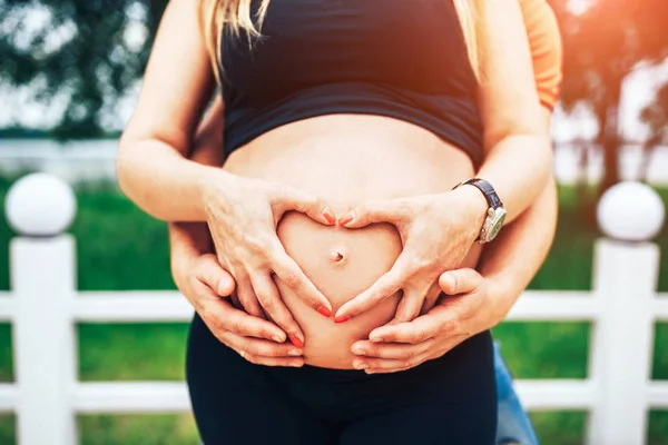 Zwangere vrouw met hartvormige handen — Stockfoto