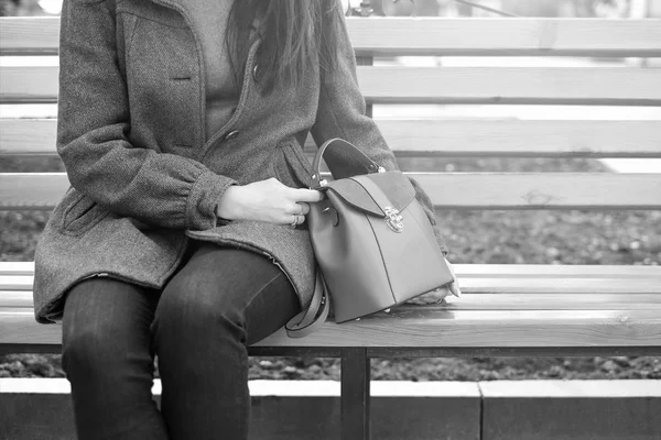 Frau sitzt mit Tasche auf Bank — Stockfoto