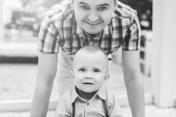 Glücklicher junger Vater mit kleinem Sohn hat Spaß im Park — Stockfoto