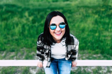 Ahşap çit oturan esmer kız 