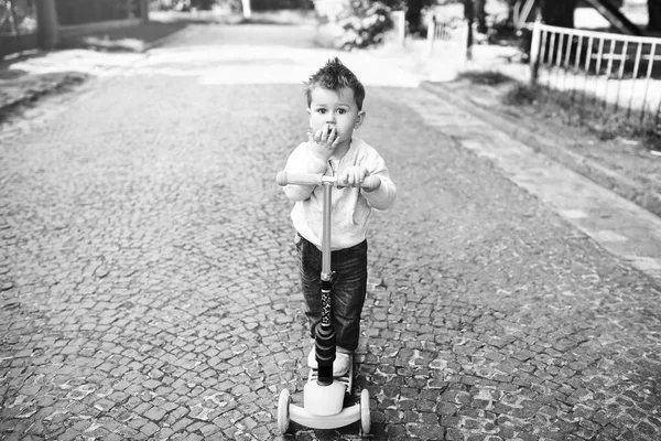 Little boy ridning scooter — Stockfoto