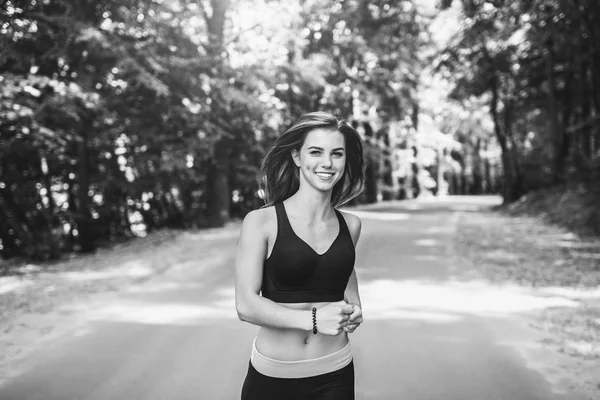 Genç bayan parkta koşuyor.