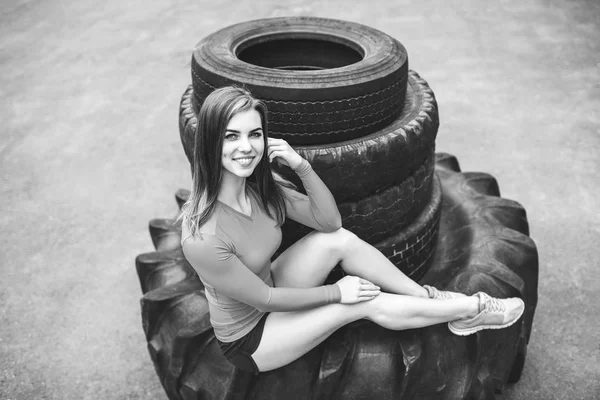 Menina posando na pilha de pneus — Fotografia de Stock