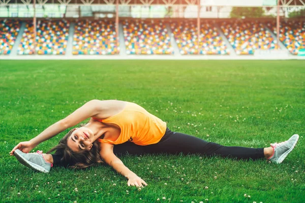 Vrouw die zich uitstrekt op voetbalveld — Stockfoto