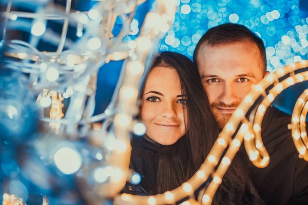 Gelukkige paar verliefd op Kerstverlichting achter — Stockfoto