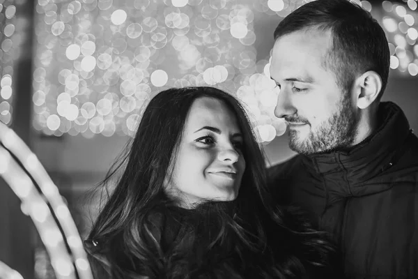 Pareja feliz enamorada de las luces de Navidad detrás — Foto de Stock