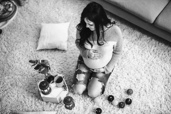 Junge glückliche schwangere Frau zu Hause mit Weihnachtsdekoration — Stockfoto