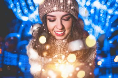 Güzel kız kış Noel ışıkları ile sokak sıcak giysiler içinde poz portresi