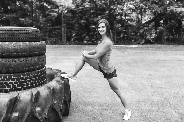 大きなタイヤと屋外のかなりスポーティな女の子トレーニング — ストック写真