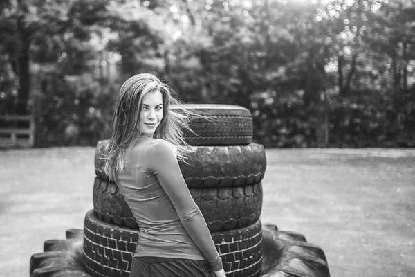 Bastante deportivo chica entrenamiento al aire libre con neumático grande —  Fotos de Stock