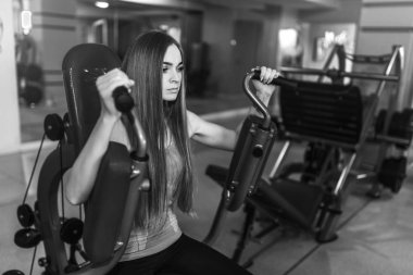 Güzel genç bir bayanla uzun saç eğitim salonunda. Genç kadın fitness ekipmanları ile egzersiz