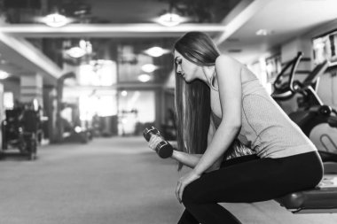 Güzel genç bir bayanla uzun saç eğitim salonunda. Genç kadın fitness ekipmanları ile egzersiz