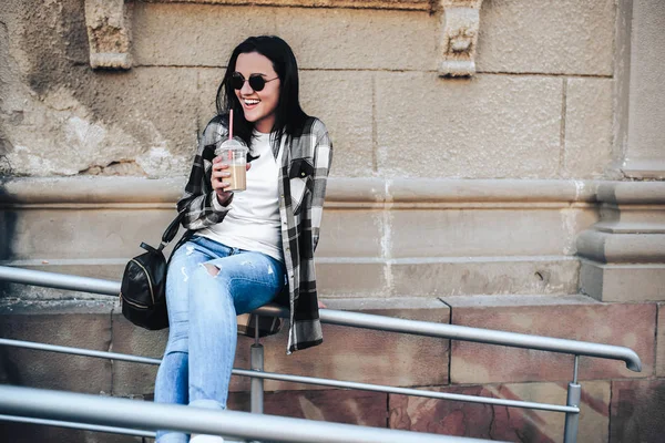 戴墨镜的漂亮黑发女孩喝着冰冷的咖啡户外 — 图库照片
