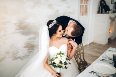Damat şefkatle genç gelin gelinlik içinde öpüşme