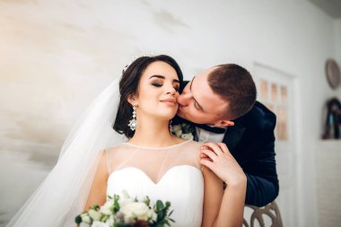Damat şefkatle genç gelin gelinlik içinde öpüşme