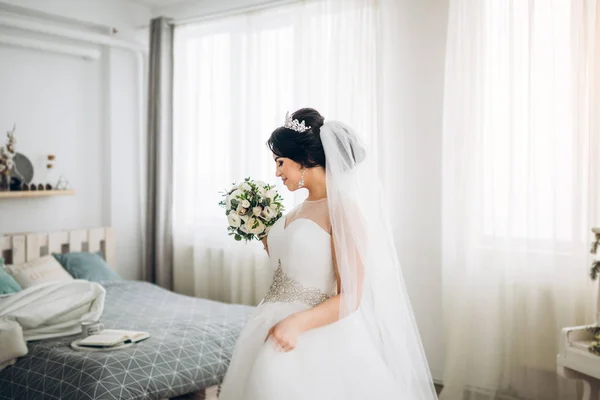 young bride in elegant dress holding wedding bouquet