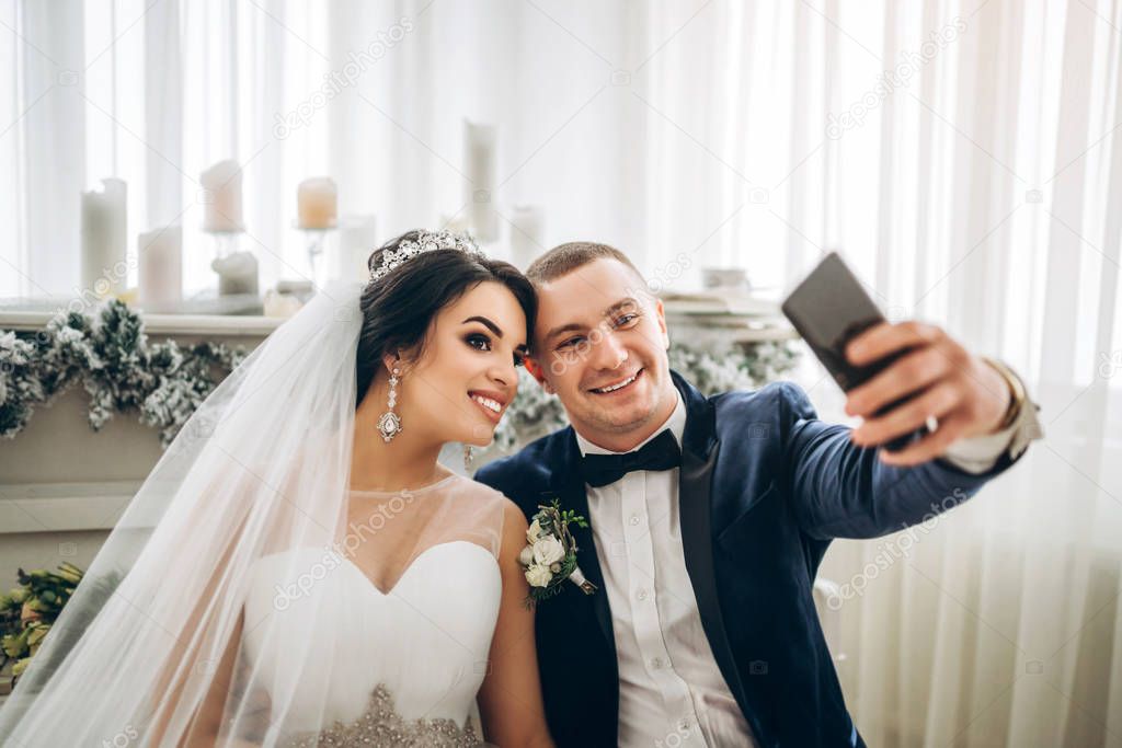 Bride with groom taking selfie before ceremony