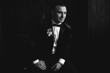 Ahşap arka plan önünde genç damat portresi