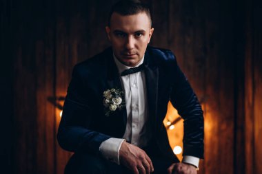 Ahşap arka plan önünde genç damat portresi