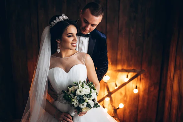 Para Młoda Ślub Pozują Przed Drewniane Ściany Światłami — Zdjęcie stockowe