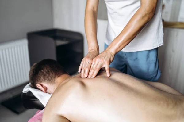 Žena fyzioterapeut dělá masáž zad pro muže v medi — Stock fotografie