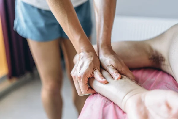 Una fisioterapeuta mujer haciendo masaje de espalda para un hombre en el medi — Foto de Stock