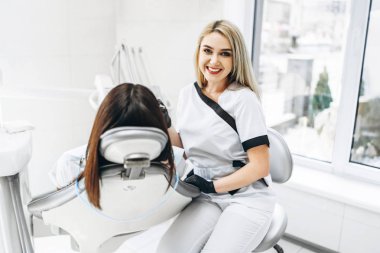 Ofisinde çalışan bir dişçi. Siyah parıltı takan bir kadın doktor.