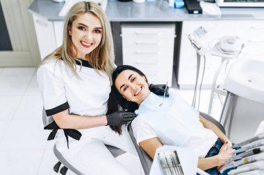 Ofisinde çalışan bir dişçi. Siyah parıltı takan bir kadın doktor.