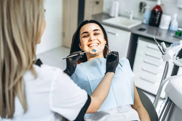 Ofisinde çalışan bir dişçi. Siyah parıltı takan bir kadın doktor. — Stok fotoğraf