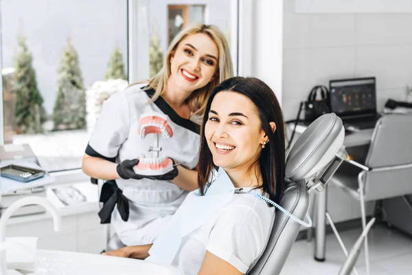 Dentiste travaillant dans son bureau. Une femme médecin montre patient 3d — Photo