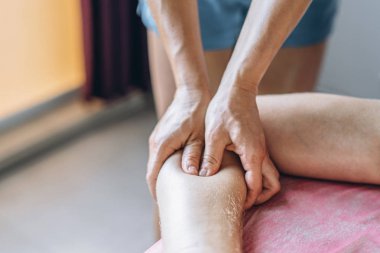 Bir kadın fizyoterapist, tıptaki bir adam için sırt masajı yapıyor.