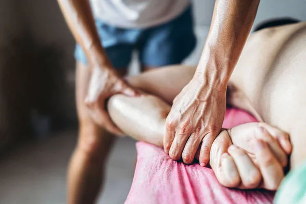En kvinnlig sjukgymnast gör ryggmassage för en man i medicinen — Stockfoto