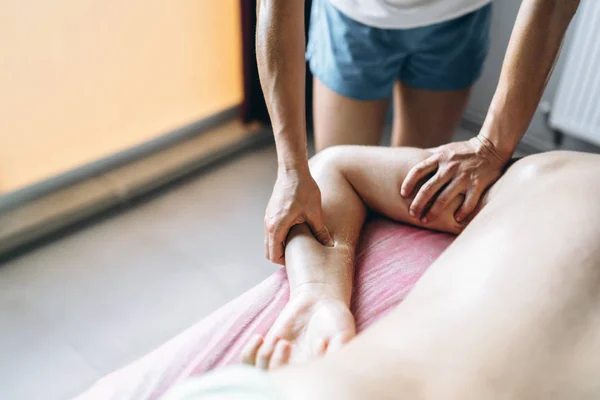 Una fisioterapeuta mujer haciendo masaje de espalda para un hombre en el medi — Foto de Stock