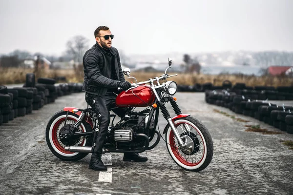 Motocicleta vermelha com piloto. Um homem com uma jaqueta de couro preto e pa — Fotografia de Stock