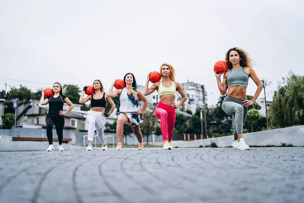 Um grupo de mulheres esportivas estão posando na câmera, realizando exercícios — Fotografia de Stock