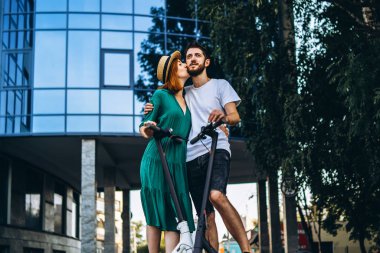 Elektrikli sandalyesi olan genç romantik bir çiftin tam boy portresi.