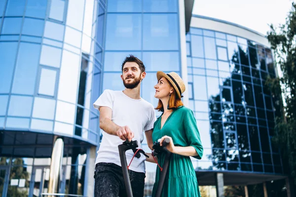 Een jong romantisch paar met elektrische scooters op een date, walkin — Stockfoto