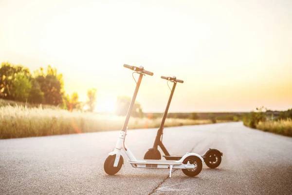 İki elektrikli scooter, siyah ve beyaz, tam ortada duruyor. — Stok fotoğraf