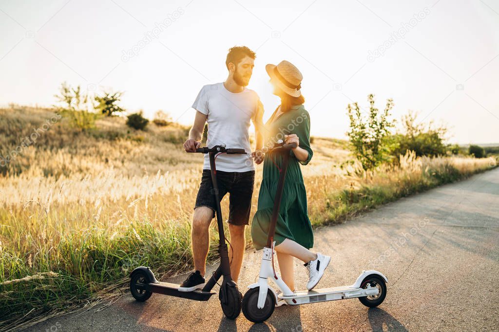 Portrait of young couple at sunset with beautiful natural landsc
