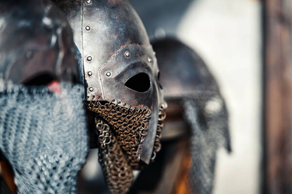 Profile of medieval old knightly helmets for protection in battle. Heavy headgear on a stand. Medieval armor concept.