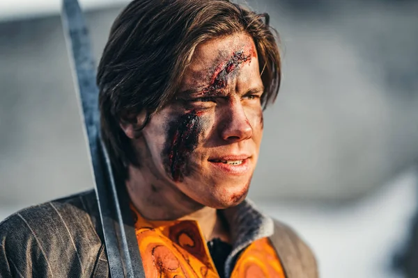 Retrato de um jovem guerreiro medieval em armadura com espada em seu — Fotografia de Stock